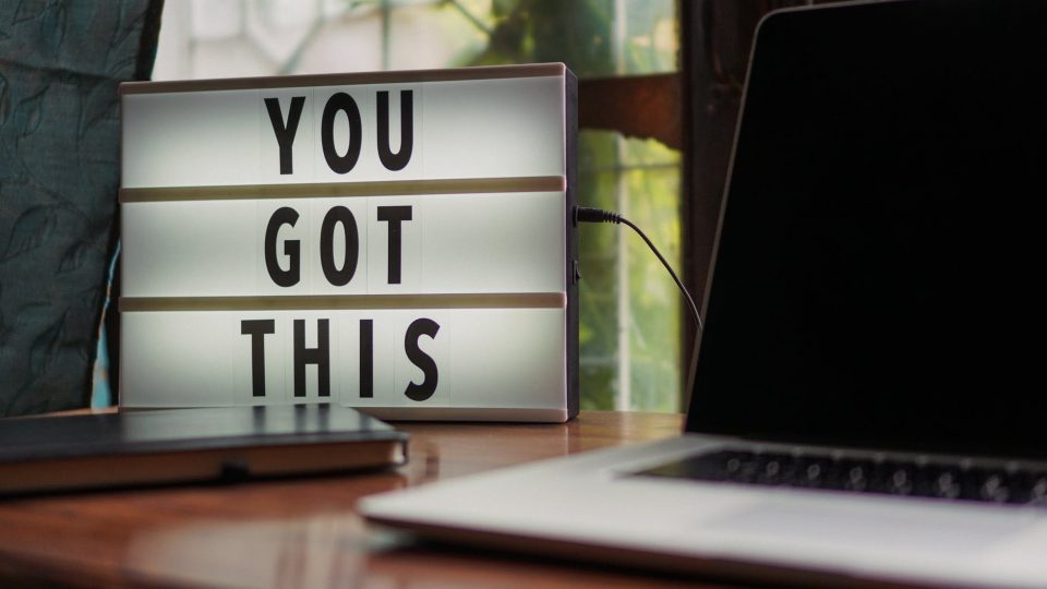 laud arvuti ja valguskastiga, millel kiri "You Got This"